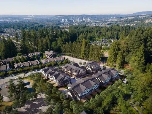 Photorealistic 3D rendering of a modern multi‑family residential complex in a wooded landscape